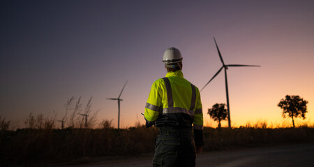 Aufkleber - Engineer man working with tablet at windmill farm Generating electricity clean energy. Wind turbine farm generator by alternative green energy.