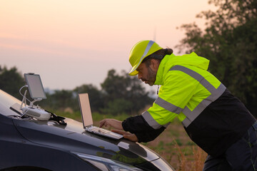 Aufkleber - Engineer working on laptop in front of wind turbines for checking wind turbines of the field during beautiful sunset. Alternative energy concept.