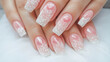 © Quang - Beautifully designed pink and white nails with heart patterns displayed on a soft surface
