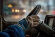 © whitestorm - A close-up of a driver's gloved hand gripping a steering wheel, focusing on safety and control during a snowy winter day on the road.