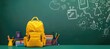 © Iram - a yellow backpack surrounded by various school supplies, Copy space text, including pencils, an apple, and books, set against a green chalkboard background