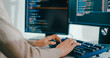 © tirachard - Closeup young adult Asia female freelance type write prompt AI bot IT app smart program nomad, video game, terminal with coding language, user interface, designer, big data center on desktop computer.