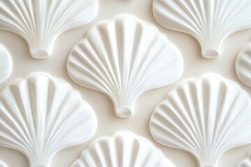 Close up shot of several white decorative fan shaped objects arranged in a repeating pattern on a surface
