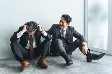 Poster - オフィスの床に座り込む同僚を励ますミドルエイジ男性ビジネスパーソン