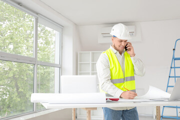 Wall Mural - male contractor talking by mobile phone in room