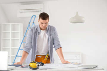 Wall Mural - male contractor working at table in room