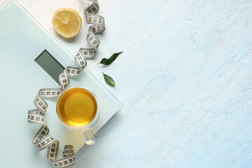 Wall Mural - Composition with cup of diet tea, scales, measuring tape and lemon on light background. Weight loss concept