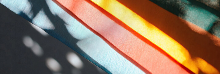 Poster - multicolored fabric strips with diagonal sunlight shadows