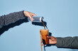 © Seventyfour - Hand pouring coffee from silver can into clear glass cup held by another hand against simple blue background Concept of enjoying refreshing beverage together
