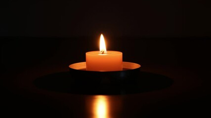 Aufkleber - Softly Glowing Candle in a Dark Room Creating a Serene Atmosphere with Gentle Light Reflections on the Floor Surrounded by a Calm Setting