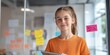 © Andrii Zastrozhnov - Smiling caucasian female teen in orange shirt holding tablet in modern office setting