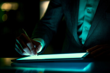 Poster - A person in a suit using a stylus on a glowing tablet in a dimly lit environment with dark background