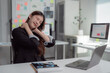 © Tj - Young asian businesswoman is massaging her neck while working on a laptop in the office, suffering from neck pain after long time working on computer laptop