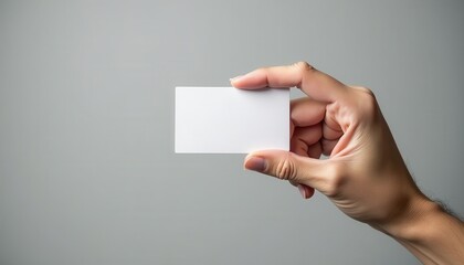 Poster - A hand holds a blank white card against a plain gray background, perfect for customizing branding or designs. The clean and minimalist mockup suits professional or creative presentations