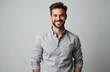 © Maryna - Handsome man with a friendly smile looking at camera. Happy male with beard wearing a shirt, posing in studio. Portrait of a confident person on grey background.