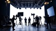© Silard - A professional film studio production set with a full crew working behind the scenes, featuring large lighting equipment, motion picture cameras, and silhouetted figures creating cinematic scenes