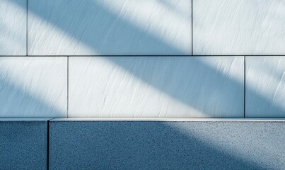 Poster - Sunlight casts a soft shadow across an exterior wall of textured, geometric tiles and base.