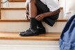 © Wavebreak Media - Child adjusting socks on staircase, preparing for school in uniform