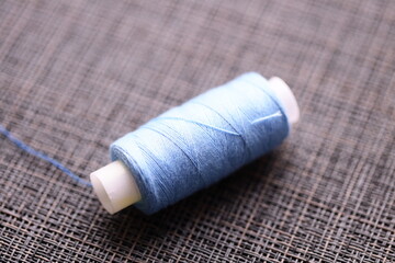 Poster - A spool of thread sits on top of a table, ready for use.