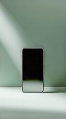 Poster - Cell phone rests against a pastel green wall, basking in the soft light. Sleek tech still life.