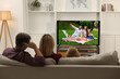 © New Africa - Family watching movie on TV set at home