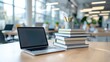 © Sarut - An organized workspace with a laptop computer stack of books and office supplies on a tidy wooden desk in a modern well lit office environment
