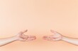 © Andrei - two hands reaching out towards each other against simple soft-colored background symbolizing connection and support