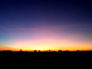 Wall Mural - dreamy purple sky twilight background and sunlight with copy space. silhouette of city.