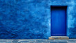 © IrisFocus - A vibrant blue door stands out against a textured blue wall, creating a captivating contrast.