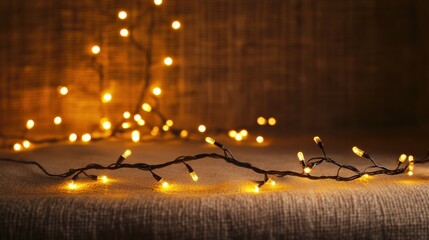 Poster - Illuminating Warmth: A string of warm-toned fairy lights casts a soft, inviting glow, dancing across a textured surface, creating a cozy and enchanting atmosphere.