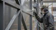 © NguyenHaiPhuong - Worker spray painting metal structure outdoors soft natural light. AI Generated