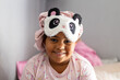 © Cavan Images - Smiling young girl with eye mask and hair bonnet on