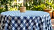 © kyle - Stylized blue-white checkered tablecloth with bokeh-enhanced blurred foliage backdrop, summer picnic product staging template for e-commerce food photography, brand style guides, and artisan market pr