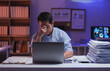 © Phimwilai - Stressed asian businessman is massaging his nose and having a headache from working late at night in office using laptop while sitting at desk with stacks of paperwork