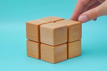 Poster - Creative hands manipulating wooden puzzle cubes on a bright blue background