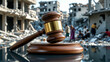 © Syuhuud - A wooden judge’s gavel with a golden band resting on a polished sound block, placed on a reflective surface. In the background, a war-torn city with destroyed buildings and civilians seeking refuge