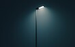 © creatfive - Single streetlight illuminates a dark, moody night scene.  The light casts a soft glow against a deep blue-gray background.  Minimalist and atmospheric