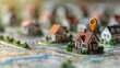 © Stanley - Finding Home: Miniature houses rest on a map, pinpointing a location with an orange marker.