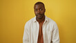© Krakenimages.com - Young african american man isolated against a vibrant yellow background in a casual white shirt