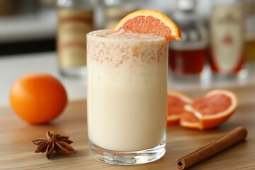 Poster - Refreshing citrus drink garnished with orange slice and spices on wooden countertop in bright kitchen
