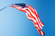 © Tetra Images - Ow angle view of American Flag against blue sky