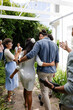 © Wavebreak Media - Bride and groom walking arm in arm, surrounded by joyful friends outdoors