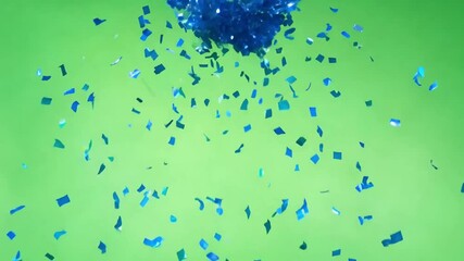 Poster - Blue Confetti Explosion: A mesmerizing display of blue confetti erupting against a vibrant green backdrop, evoking feelings of celebration and joy.