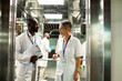 © Marko Geber - Two diverse medical professionals walking in hospital corridor