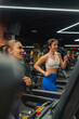 © Zamrznuti tonovi - Two young women running on treadmills in modern gym
