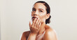© KayExam/peopleimages.com - Beauty, skincare and woman with cosmetics, shine and dermatology on white studio background. Person, mockup space and model with confidence, wellness and healthy skin with acne treatment and glow