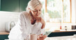 © KayExam/peopleimages.com - Relax, phone and reading with old woman in kitchen for retirement fund, social security benefits or news. Senior discount, membership application and update with person at home for annuity sign up