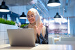 © maya1313 - Cheerful muslim lady in hijab working online at cafe, using laptop, copy space. Side view of smiling arab woman freelancer typing on laptop, enjoying her distant job, Muslim working woman concept.