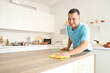 © Pixel-Shot - Young man cleaning table in kitchen