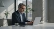 © AlfaSmart - Business professional working on laptop in modern office environment